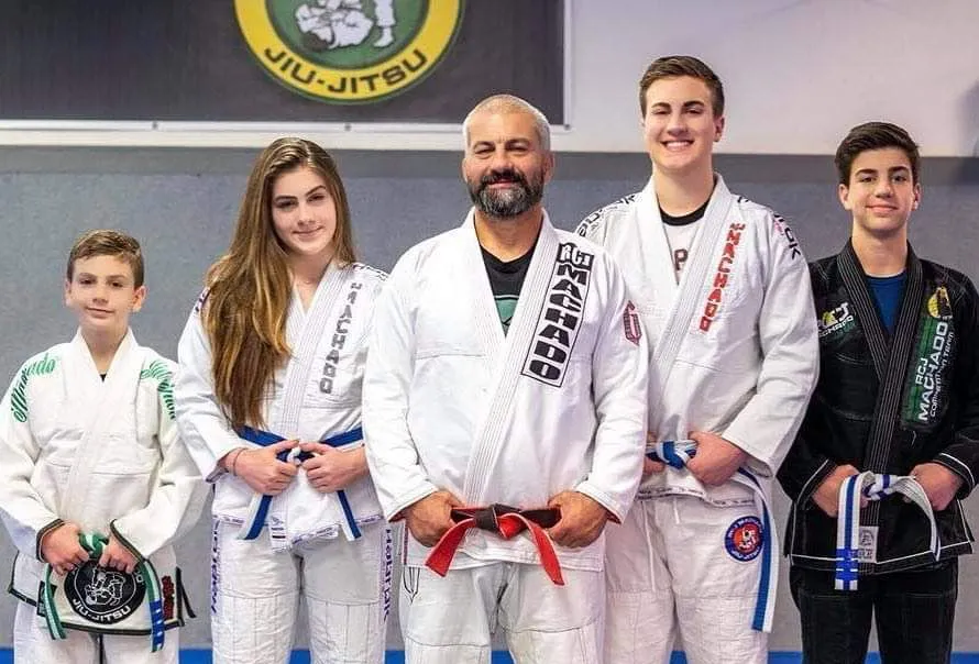 Master Carlos Machado with his family and students in their gis at the Machado Method academy in Carrollton, TX