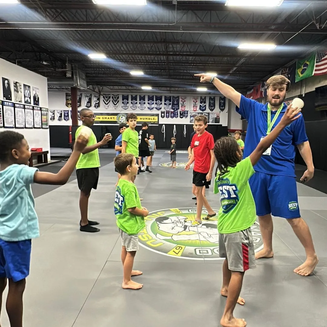 Machado Method summer campers and their coach playing a game on the mat in Carrollton, TX